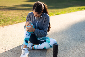 Young sporty woman has knee pain