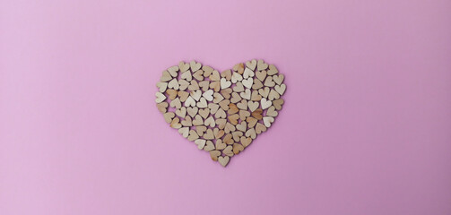 A big heart made of many small wooden hearts on a pink-purple background. Cute Valentine's Day card