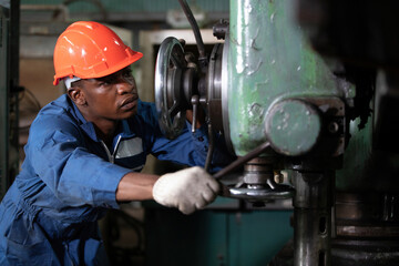 male african workers or technician checking and control lathe machine in factory