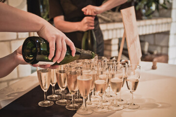 Serveurs versant du champagne dans des verres lors d'un mariage