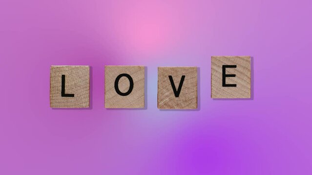 text - Love on Animated purple wooden blocks on trending pink multi colored animation background. High quality 4k motion design graphics art footage.Romantic Love concept for mother's, St. Valentine's
