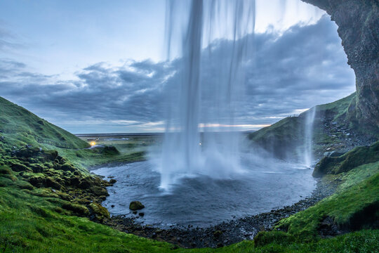 Wassermassen des Wasserfalls Seljalandsfoss st&uuml;rzen hinab in einen See.