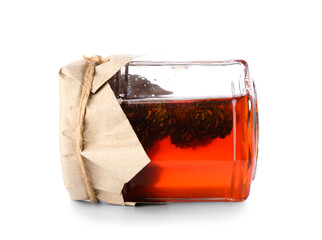 Jar of tasty pine cone jam on white background