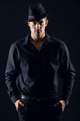 Fototapeta na wymiar Portrait of fashionable gentleman in stylish hat against dark background