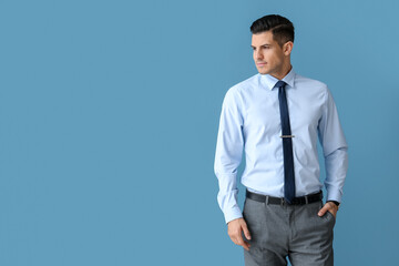 Handsome man in formal clothes on color background