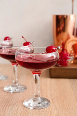 Glasses of tasty Manhattan cocktail on wooden table, closeup