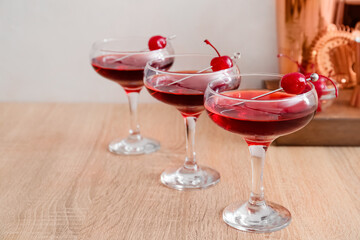 Glasses of tasty Manhattan cocktail on wooden table, closeup