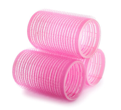 Pink hair curlers on white background