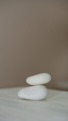 Fototapeta na wymiar Two white stones on a beige background.