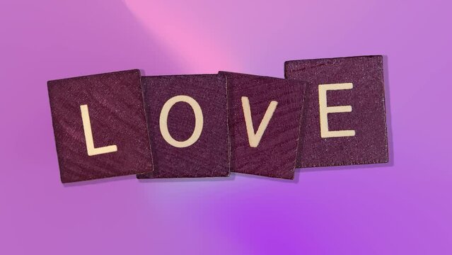 text - Love on Animated purple wooden blocks on trending pink multi colored animation background. High quality 4k motion design graphics art footage.Romantic Love concept for mother's, St. Valentine's