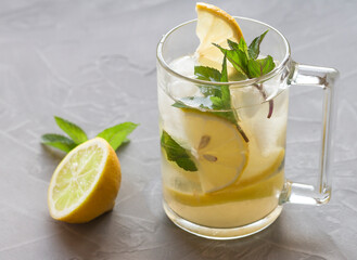homemade ice lemonade with lemon and mint on a gray background