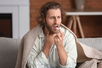 Ill man with inhaler at home