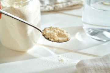 Preparation of a healthy protein drink - whey protein powder on a spoon