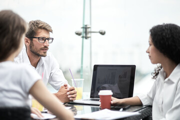 Smiling colleagues working together developing business strategy for their next project. Young casually dressed business people having discussion on sunny terrace. Modern job in comfortable conditions