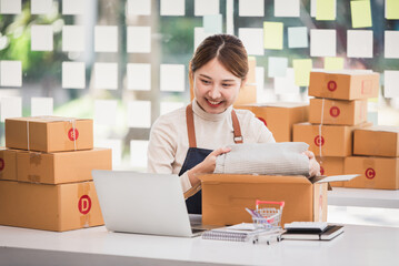 Small start-up business owners are packing boxes. To deliver to customers, salespeople, check production orders. Pack products, send to customers, sell ecommerce delivery ideas.