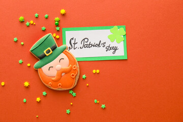Composition with tasty gingerbread cookie for St. Patrick's Day celebration on color background