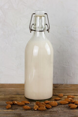 A bottle with alternative dairy free almond milk on wooden table. Lactose free beverage