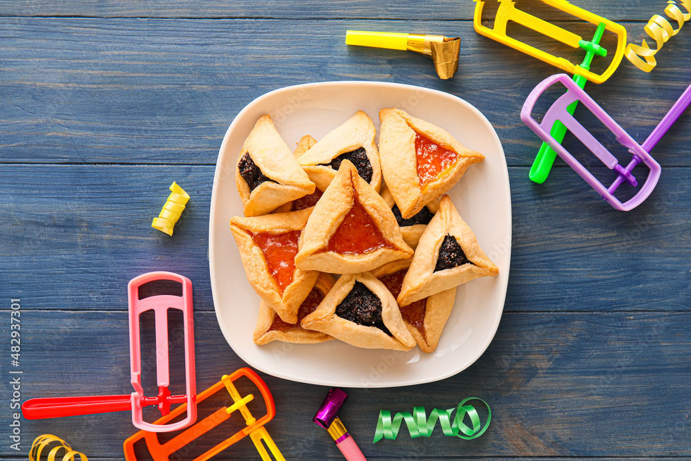 Wall mural hamantaschen cookies and rattles for purim holiday on color wooden background