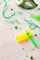 Rattle for Purim holiday with party decor on white wooden background