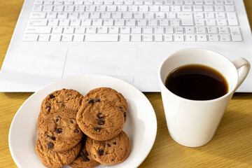 休憩時間にクッキーを食べ、ノートパソコンを使うイメージ