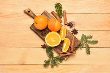 Board with fresh oranges and fir branches on wooden background