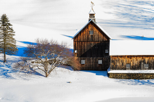 A winter photograph of a farm in Vermont with snow covered meadows.
