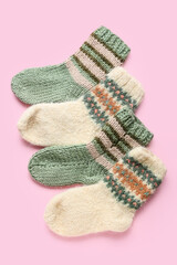 Warm knitted socks on pink background