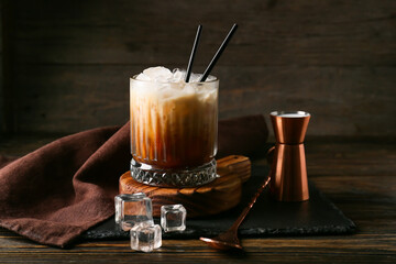 Glass of White Russian cocktail on wooden background