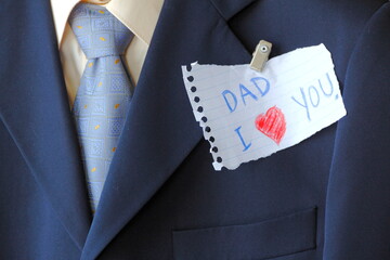 I Love DAD. Father’s Card Series. Close-up note for father pinned on his suit on father's day    