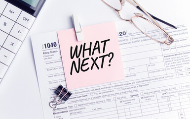 WHAT NEXT with pen, calculator, glass and sticker. Tax report sign