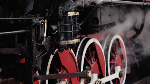Old wheels and parts of a steam engine close-up. Soviet locomotive stands
