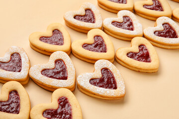 Tasty cookies in heart shape on beige background