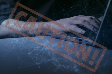 Hands at laptop with interconnectivity graphic overlay along with the word 'CAUTION' displayed large