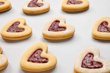 Tasty cookies in heart shape on light background