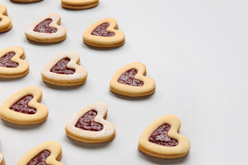 Tasty cookies in heart shape on light background