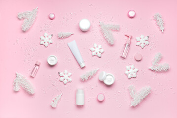 Cosmetic products and winter decor on color background