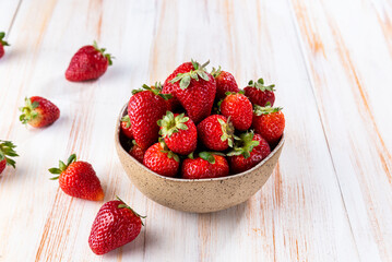 strawberries in a bowl on a wooden table