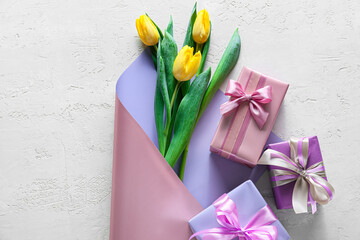Beautiful tulip flowers and gift boxes for International Women's Day on light background