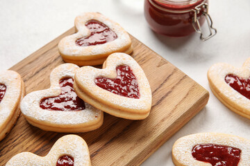 Board with tasty cookies for Valentine's Day celebration on light background, closeup