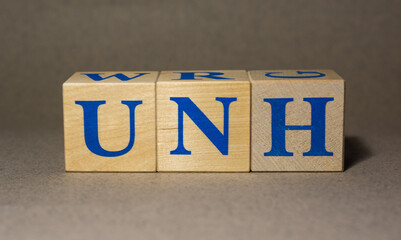 January 19, 2022. New York, USA. Exchange Ticker symbol of UnitedHealth Group Incorporated UNH, made of wooden cubes, on a gray background.