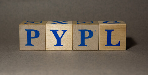January 19, 2022. New York, USA. Exchange Ticker symbol of PayPal Holdings PYPL, made of wooden cubes, on a gray background.
