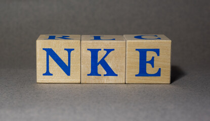 January 19, 2022. New York, USA. The Stock Ticker symbol of the NIKE NKE company, made of wooden cubes, on a gray background.