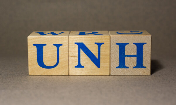 January 19, 2022. New York, USA. Exchange Ticker symbol of UnitedHealth Group Incorporated UNH, made of wooden cubes, on a gray background.
