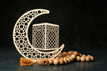 Decorative crescent and Muslim prayer beads on dark background