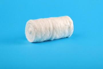 Fototapeta na wymiar Roll of medical cotton wool on a blue background