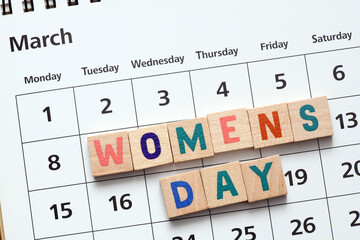 WOMEN'S DAY words arranged from wooden letters on a calendar. March 8 Women's Day.