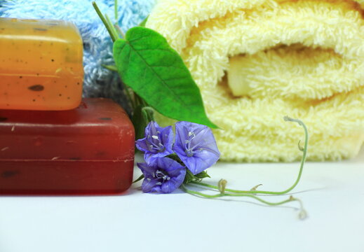 Spa concept. Spa concept with towels, bar of soap, and blue flowers (Jacquemontia pentanthos).