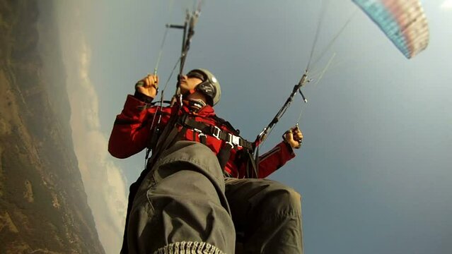 Paraglider pilot performing a spiral dive in the mountains of Nepal