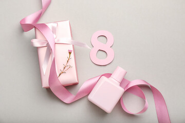 Composition with figure 8, gift box and perfume bottle for International Women's Day celebration on grey background