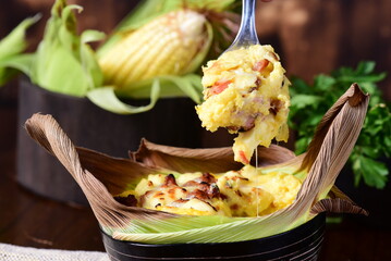 delicious corn pamonha, typical Brazilian food, baked corn cake with seasonings and melted and...